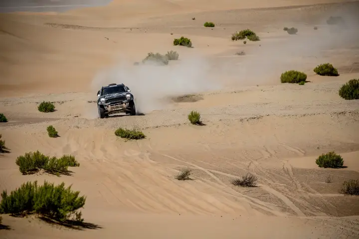 Abu Dhabi Desert Challenge 2018: Mini crossing flat desert scrubland leaving dust trail