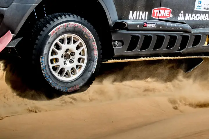 Abu Dhabi Desert Challenge 2018: close-up Mini front wheel spraying sand at speed