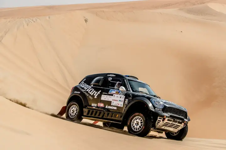 Abu Dhabi Desert Challenge 2018: black Mini navigating sandy desert landscape at speed