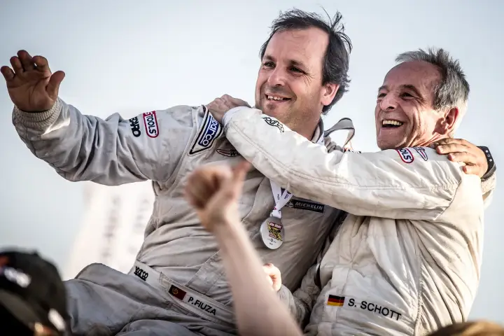 Abu Dhabi Desert Challenge 2018: two drivers embracing celebrating race victory
