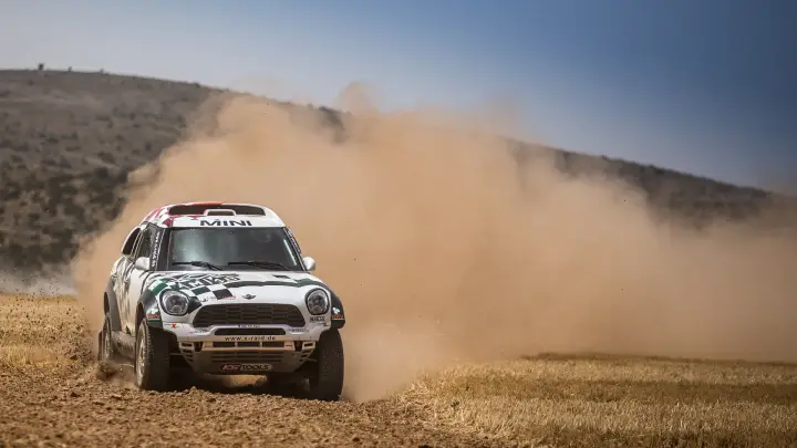 Baja Aragón 2016: Mini race car kicking dust on dry hillside
