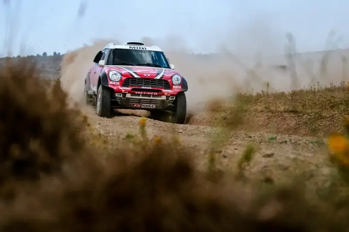Baja Aragón 2017: red Mini head-on racing on dusty gravel road