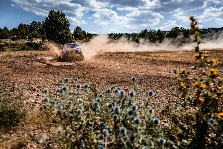 Baja Aragón 2021: Mini racing distant on red dirt with wildflowers