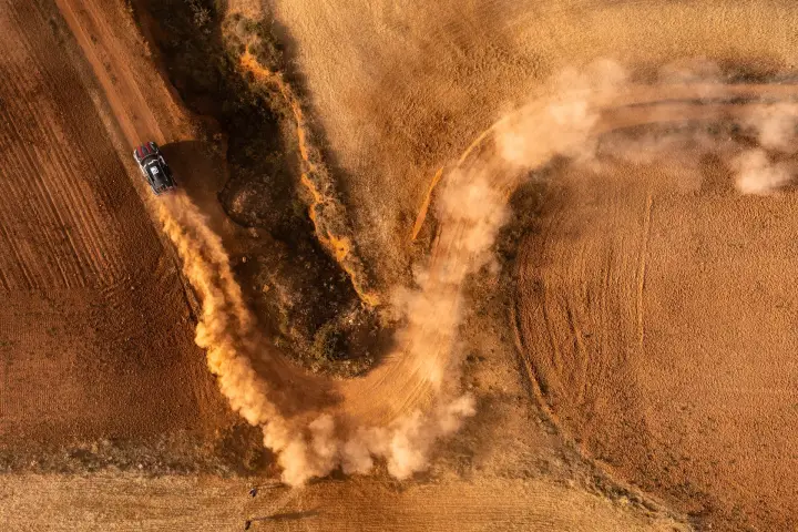 Baja Aragón 2021: aerial drone view rally car turning on red earth