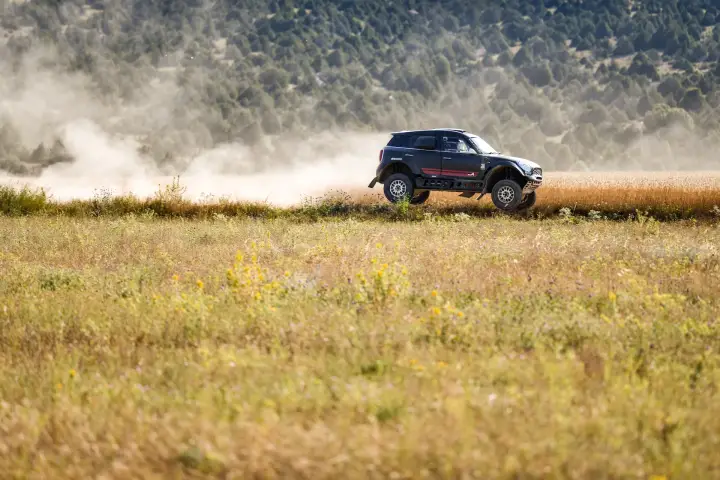 Baja Aragón 2021: dark Mini distant silhouette speeding through wheat field
