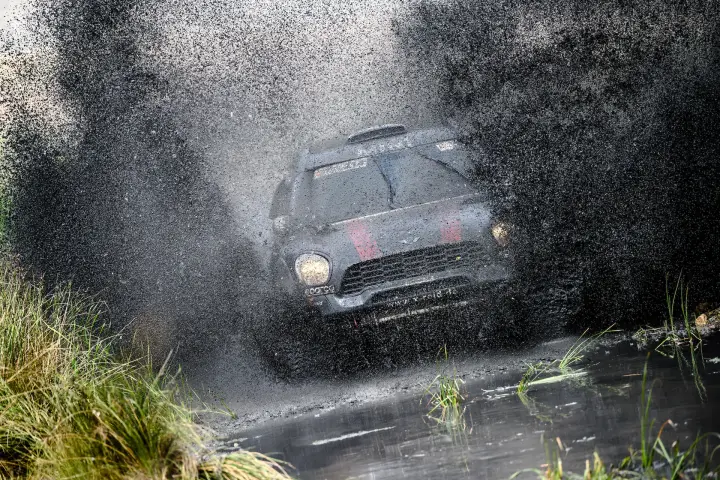 Baja Aragón 2021: dark Mini head-on exploding through muddy water splash