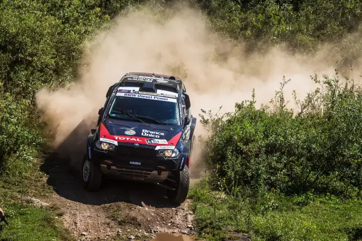 Dakar Rally 2013: BMW speeding through green vegetation dirt track