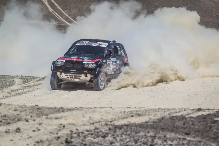 Dakar Rally 2013: BMW charging through sandy dust flat terrain