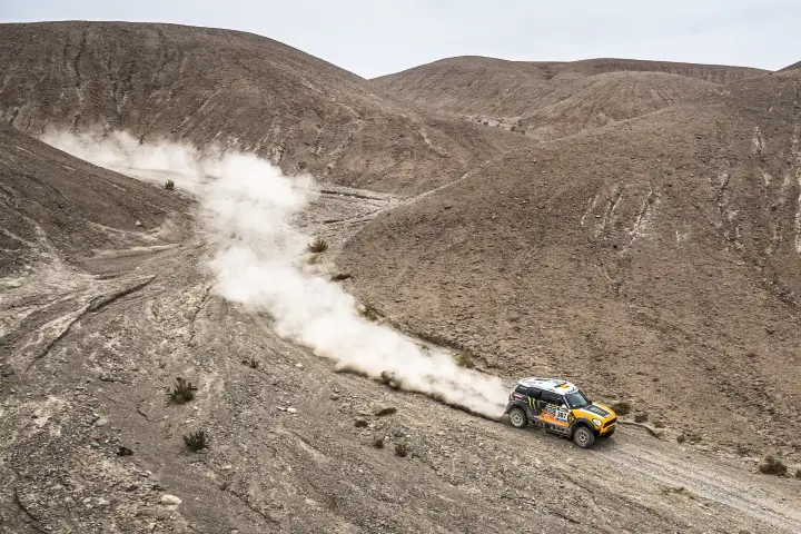 Dakar Rally 2014: Mini on barren hillside raising dust cloud