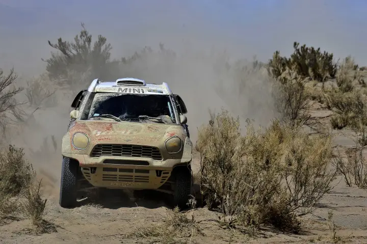 Dakar Rally 2017: heavily dusty Mini through sparse desert bushes