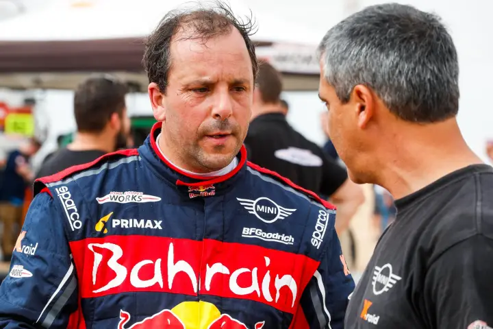 Dakar Rally 2020: two drivers in race suits talking closely