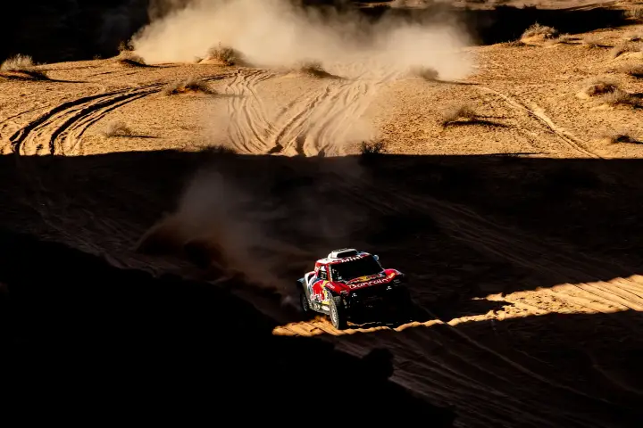 Dakar Rally 2020: dramatic shadow dunes car raising dust cloud above