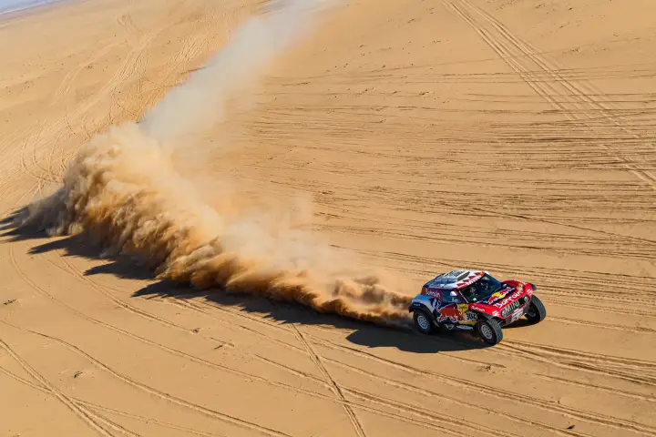 Dakar Rally 2020: overhead view car raising tall dust column desert