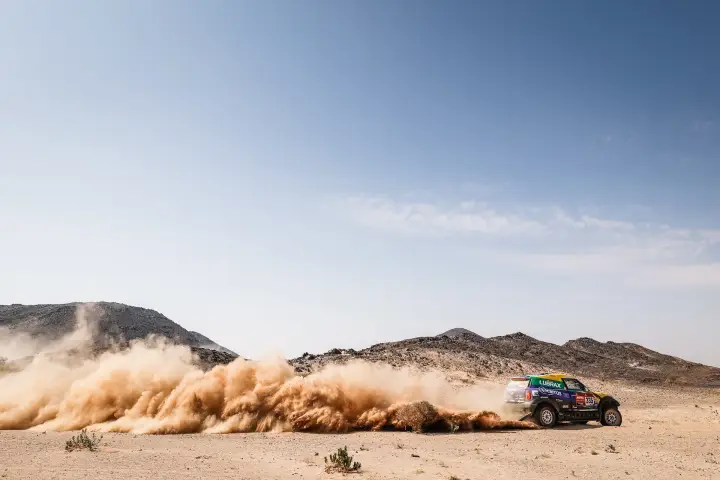 Dakar Rally 2021: blue Mini racing through Saudi desert dust trail