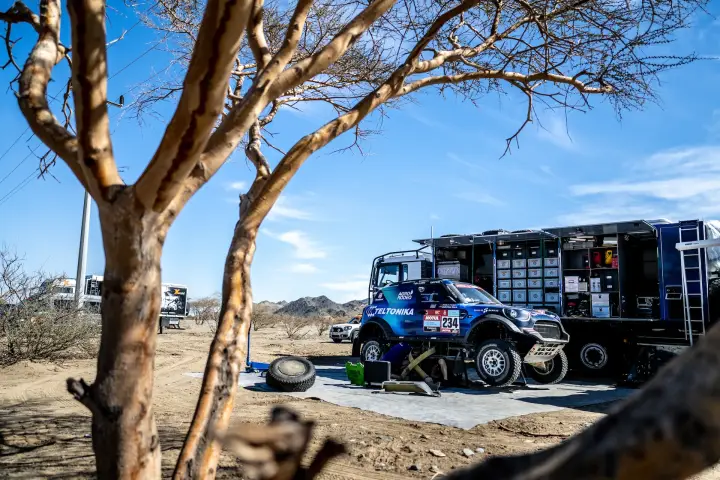 Dakar Rally 2022: team servicing car and tyres at bivouac