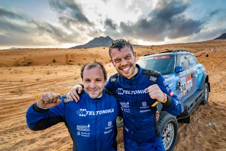 Dakar Rally 2022: two drivers celebrating fist pumping in desert