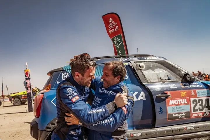 Dakar Rally 2022: driver and co-driver hugging celebrating at finish