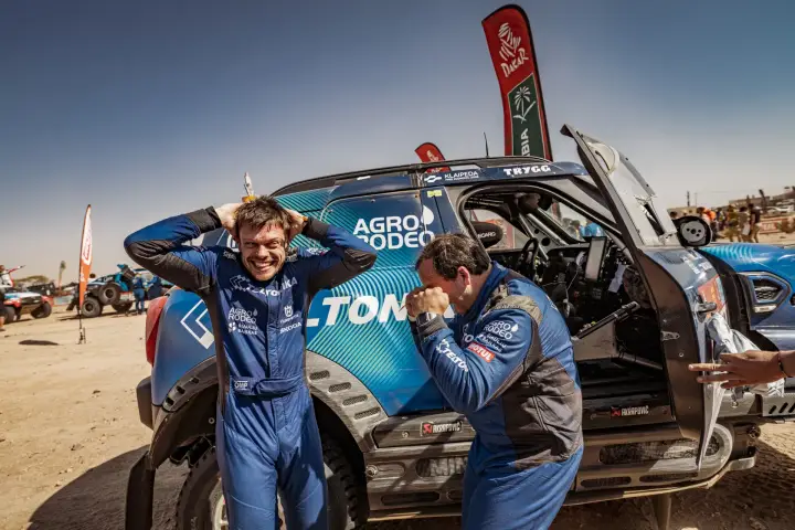 Dakar Rally 2022: two drivers laughing celebrating next to race car