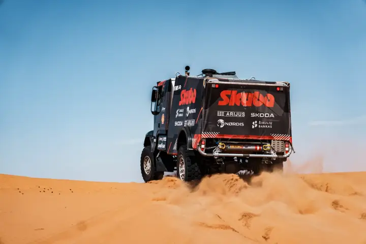 Dakar Rally 2025: Skuba truck rear view climbing golden desert dune