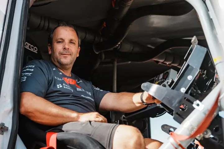 Dakar Rally 2025: driver smiling in truck cab Skuba team shirt