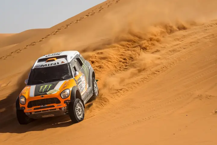 Rallye du Maroc 2013: orange Mini sliding up steep Moroccan sand dune