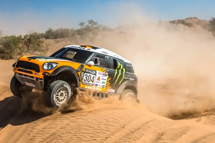 Rallye du Maroc 2013: orange Mini sliding through sandy Moroccan terrain