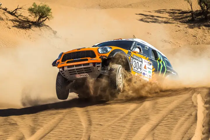 Rallye du Maroc 2013: orange Mini jumping airborne through Moroccan desert