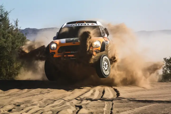 Rallye du Maroc 2013: orange Mini jumping fully airborne on dirt road