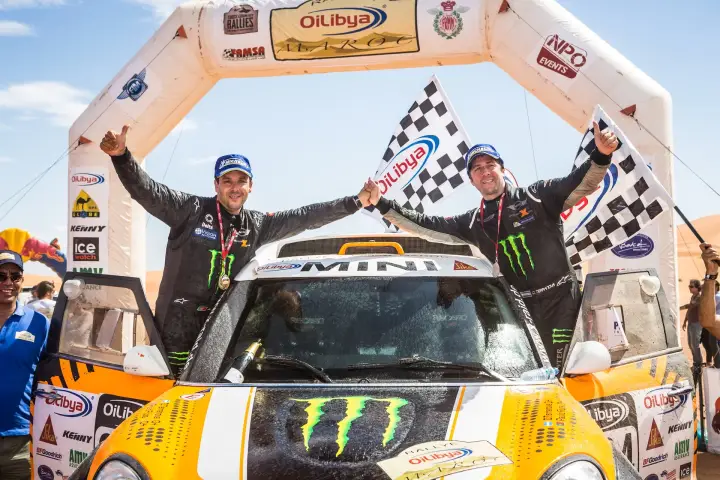 Rallye du Maroc 2013: two drivers celebrating victory waving checkered flag