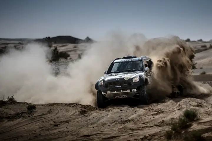 Rallye du Maroc 2016: black Mini racing through sandy dust cloud Morocco
