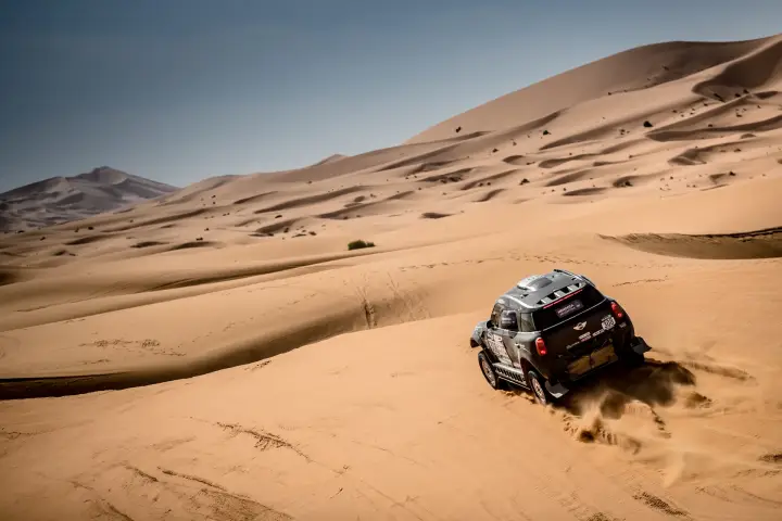 Rallye du Maroc 2016: black Mini tiny against massive Moroccan dune landscape