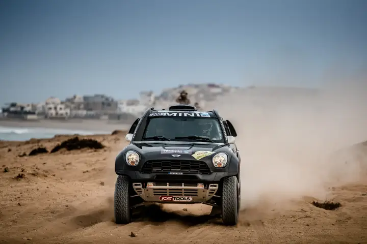 Rallye du Maroc 2016: black Mini head-on driving on coastal Moroccan beach
