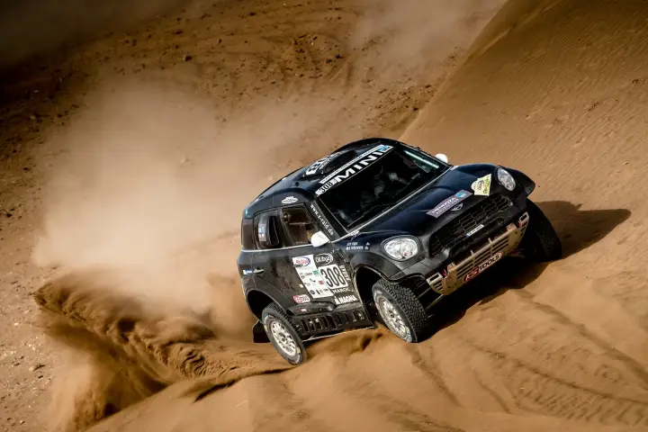Rallye du Maroc 2016: black Mini cornering fast on Moroccan sand dune