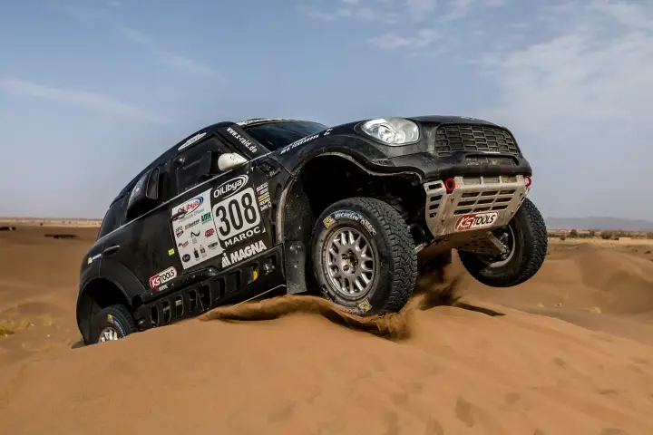 Rallye du Maroc 2016: Mini leaning on two wheels over sand dune edge