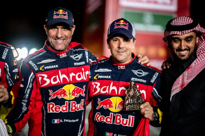 Pódio: Peterhansel and Fiuza holding Dakar trophy with Saudi official