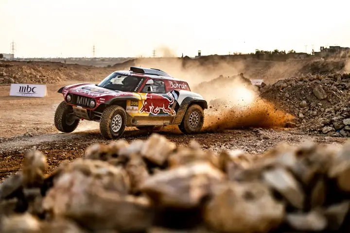Riyadh Rally 2019: red Mini racing over rocky terrain with dust cloud